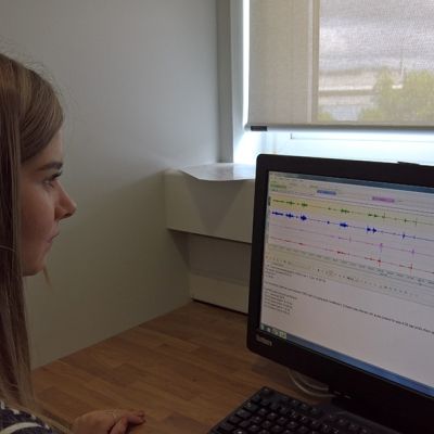 A student looking at a computer screen which has various graphs on